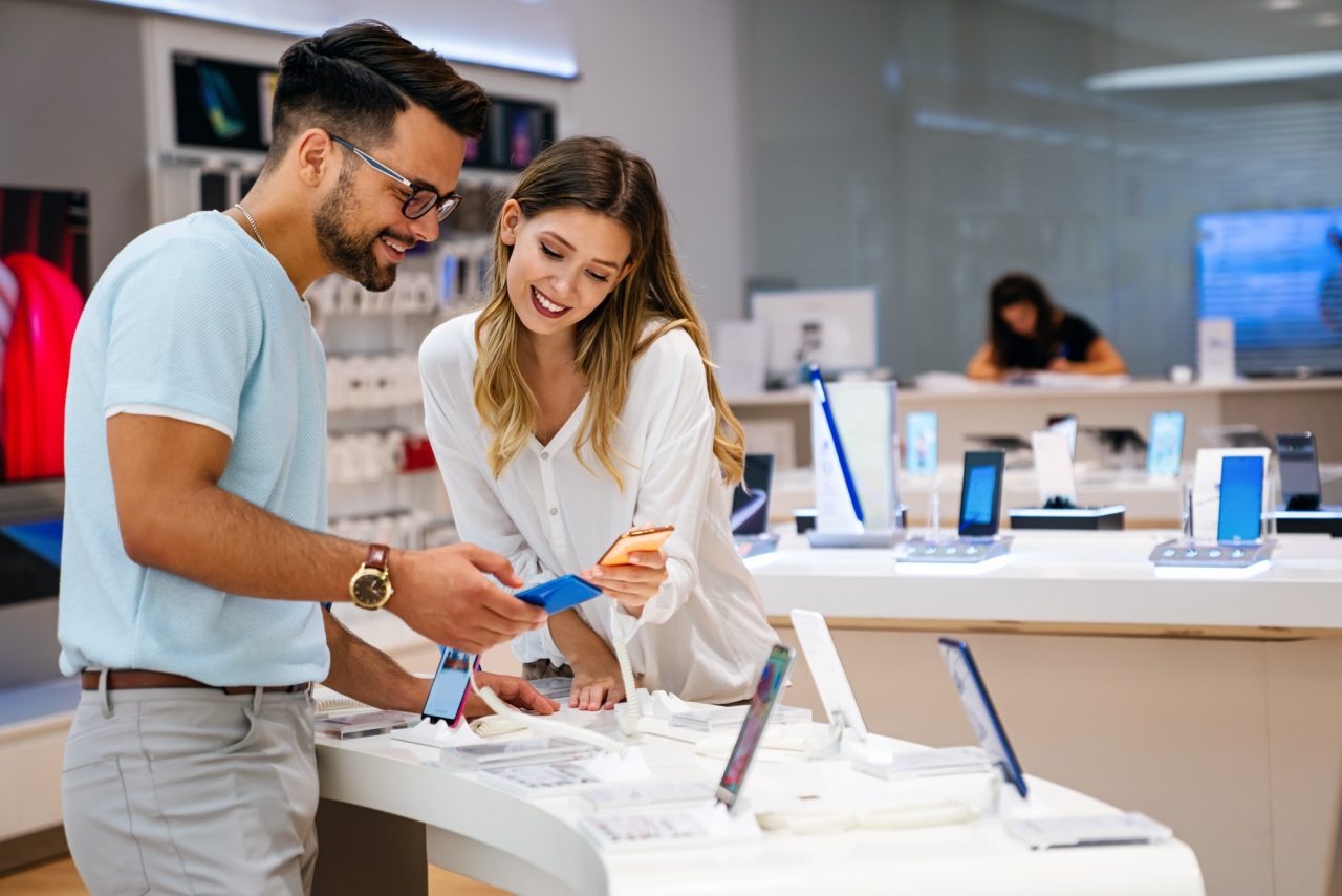 shopping a new digital device happy couple buying a smartphone in store